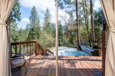 a screened in deck with a view of the woods at Tiny home with spa/firepit/and more in Oakhurst