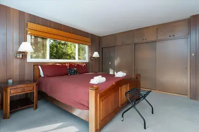 a bedroom with a bed with red sheets and a window at River's Edge w/ BBQ, Wifi, Firepit in North Wawona