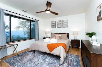 a bedroom with a bed and a large window at Vista Haven with stunning views/hot tub/mini golf in Oakhurst