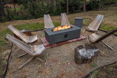 two chairs and a fire pit in a yard at Bass Lake Chalet- A frame with hot tub/firepit in Oakhurst