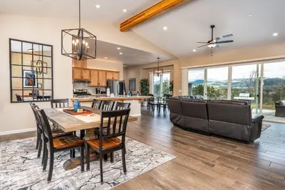 a kitchen and living room with a table and chairs at Mountain View House with hot tub, putting green, stunning views in Oakhurst