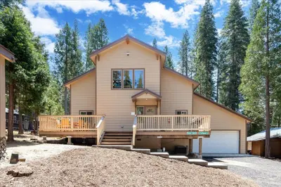 a house with a large porch and a deck at Base Camp- Inside Yose w pool table/grill in North Wawona