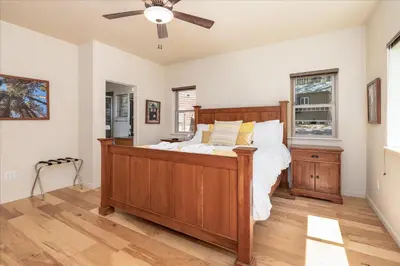 a bedroom with a wooden bed and a ceiling fan at Base Camp- Inside Yose w pool table/grill in North Wawona