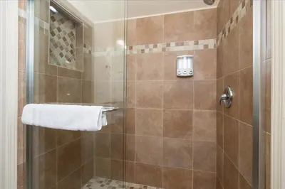 a bathroom with a shower with a glass door at Base Camp- Inside Yose w pool table/grill in North Wawona