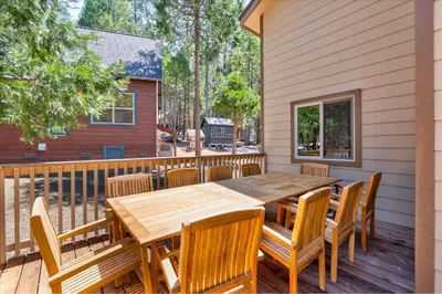 a wooden table and chairs on a deck at Base Camp- Inside Yose w pool table/grill in North Wawona