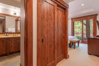 a bathroom with a wooden door and a sink at Luxury Northstar Home Walk to Lifts Private Hot-Tub Fenced-In Yard Book on Mobile for Promo Price in Truckee