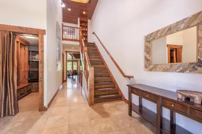 a hallway with stairs and a mirror on the wall at Luxury Northstar Home Walk to Lifts Private Hot-Tub Fenced-In Yard Book on Mobile for Promo Price in Truckee