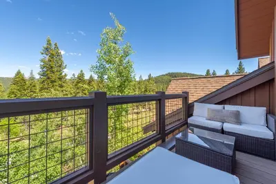 a balcony with a couch and a view of the mountains at Luxury Northstar Home Walk to Lifts Private Hot-Tub Fenced-In Yard Book on Mobile for Promo Price in Truckee