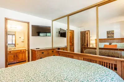 a bedroom with a bed and a large mirror at Snowflower #79 - Updated 2 Bedroom & Loft, 3 Bath, Sleeps 8, Steps away from Free Town Shuttle in Mammoth Lakes