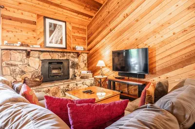 a living room with a couch and a television at Snowflower #79 - Updated 2 Bedroom & Loft, 3 Bath, Sleeps 8, Steps away from Free Town Shuttle in Mammoth Lakes