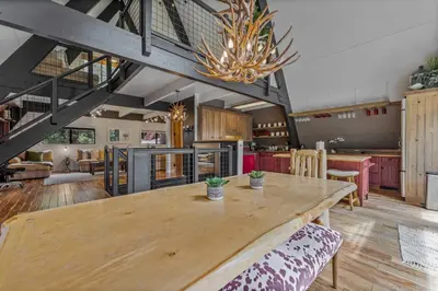 a large kitchen with a wooden table and a chandelier at 5BR A Frame Near Patton Beach with 2 Decks in Carnelian Bay