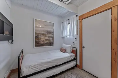 a small bedroom with a bed and a window at 5BR A Frame Near Patton Beach with 2 Decks in Carnelian Bay