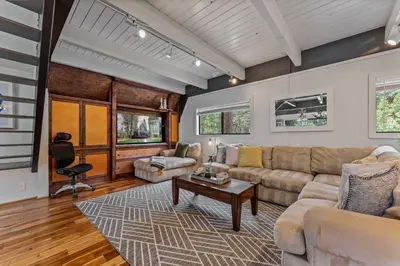 a living room with a couch and a table at 5BR A Frame Near Patton Beach with 2 Decks in Carnelian Bay