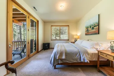 a bedroom with a bed and a desk and a balcony at Horizon at Tahoe Donner w Private Hot Tub and Mountain Views in Truckee