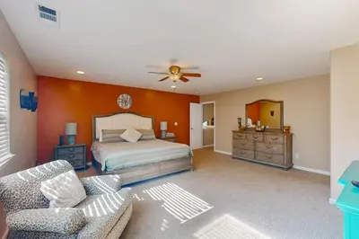 a bedroom with a bed and a couch and a fan at Creekside & Cozy in Bass Lake