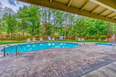 a swimming pool with two chairs at Creekside & Cozy in Bass Lake