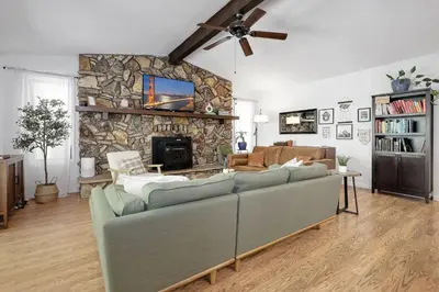 a living room with a couch and a stone wall at Home in the Pines - Apple Hill - Dog Friendly - Snow Nearby in Pollock Pines