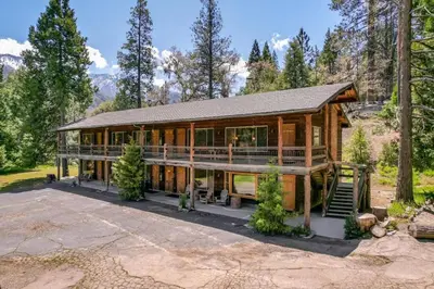 a large wooden house with glass windows at Camp Nelson Lodge Room 2 in Ponderosa