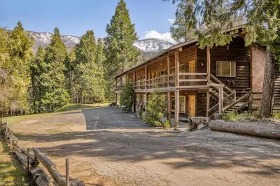 a log cabin with a driveway leading up to it at Camp Nelson Lodge Room 2 in Ponderosa