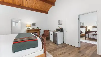 a bedroom with a bed and a living room at Camp Nelson Lodge Room 6 in Ponderosa
