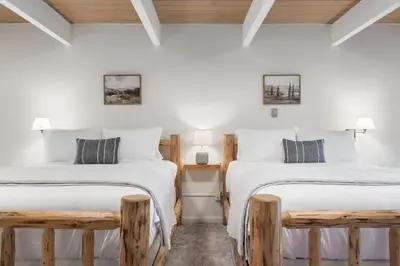 two beds in a room with white walls at Mountain Nook CN Lodge #4 in Ponderosa