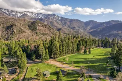 an aerial view of a green field in the mountains at Mountain Nook CN Lodge #4 in Ponderosa