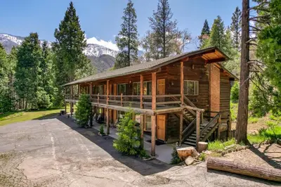 a log cabin in the woods with mountains in the background at Sierra Vista @CN Lodge #8 in Ponderosa
