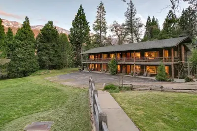 a large house with a fence in front of a yard at Bear's Den @CN Lodge #5 in Ponderosa