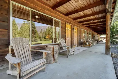 a porch of a cabin with rocking chairs and windows at Bear's Den @CN Lodge #5 in Ponderosa