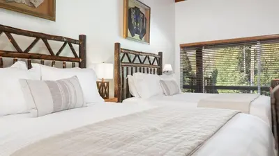 two white beds in a bedroom with a window at Camp Nelson Lodge Room 9 in Ponderosa