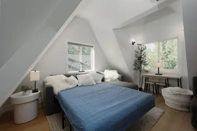 a bedroom with a blue bed in a attic at Lakefront Cottage at Lakewood in Auburn