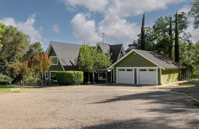a house with a driveway and a garage at Lakefront Cottage at Lakewood in Auburn