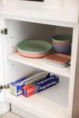 a white shelf with plates and bowls and books at Treehouse Overlook at Lakewood in Auburn
