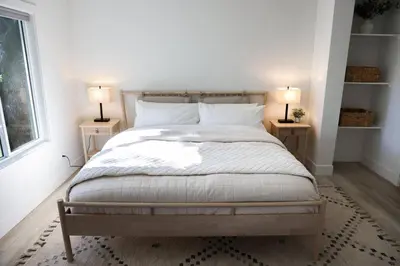a bedroom with a bed with two lamps on two tables at Treehouse Overlook at Lakewood in Auburn