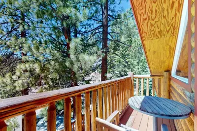 a wooden porch with a bench and a table on it at Summit Sanctuary in Stateline