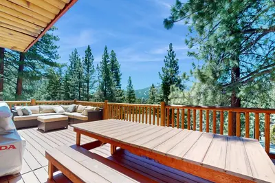 a wooden deck with a couch and a table at Summit Sanctuary in Stateline