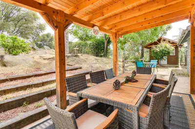 a wooden deck with a wooden table and chairs at Yosemite Wellbeing Retreat on 5 Acres with Mtn Views in Ahwahnee
