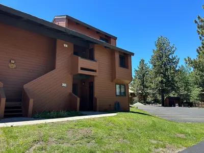 a building with a grass yard next to it at Sunrise #33 condo in Mammoth Lakes