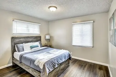 a bedroom with a large bed and two windows at Mid Century Wineries Game Room in Lodi