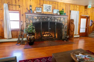 a fireplace in a living room with wooden walls at Camp Richardson Resort in South Lake Tahoe