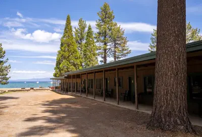 a building next to a beach with a tree at Camp Richardson Resort in South Lake Tahoe