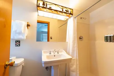 a bathroom with a sink and a shower with a mirror at Camp Richardson Resort in South Lake Tahoe