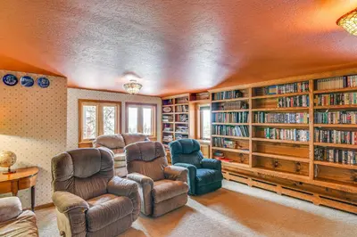 a living room with two chairs and book shelves at Game Room and Hot Tub Serene Grand Mountain Chalet! in Stateline