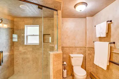 a bathroom with a toilet and a shower at Game Room and Hot Tub Serene Grand Mountain Chalet! in Stateline