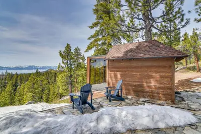 a cabin with two chairs and a table at Game Room and Hot Tub Serene Grand Mountain Chalet! in Stateline