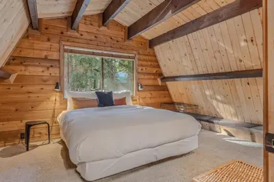 a bedroom with a bed in a log cabin at 3BR with Sauna & Lake Views, 2 miles to Beach in Tahoe City