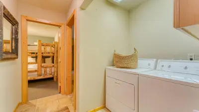 a laundry room with a washer and dryer and a bedroom at Paige Meadow by AvantStay Near Lake Tahoe City in Tahoe City