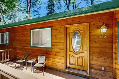 a wooden cabin with two chairs and a door at Fire Pit, Near Lake Evergreen Escape in Arnold in Arnold