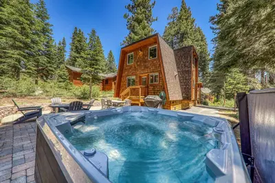 a large hot tub in front of a house at 10th Mountain Home - 4BR Tahoe Donner w Hot Tub, HOA amenities! in Truckee