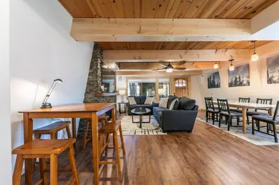 a dining room and living room with wooden ceilings at 10th Mountain Home - 4BR Tahoe Donner w Hot Tub, HOA amenities! in Truckee